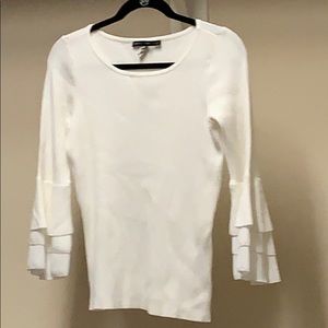 White sweater with bell sleeves.